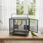 Stainless bird cage with colorful perches and a green parakeet nearby