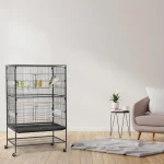 Stainless bird cage with colorful birds inside, placed in a modern living room setting
